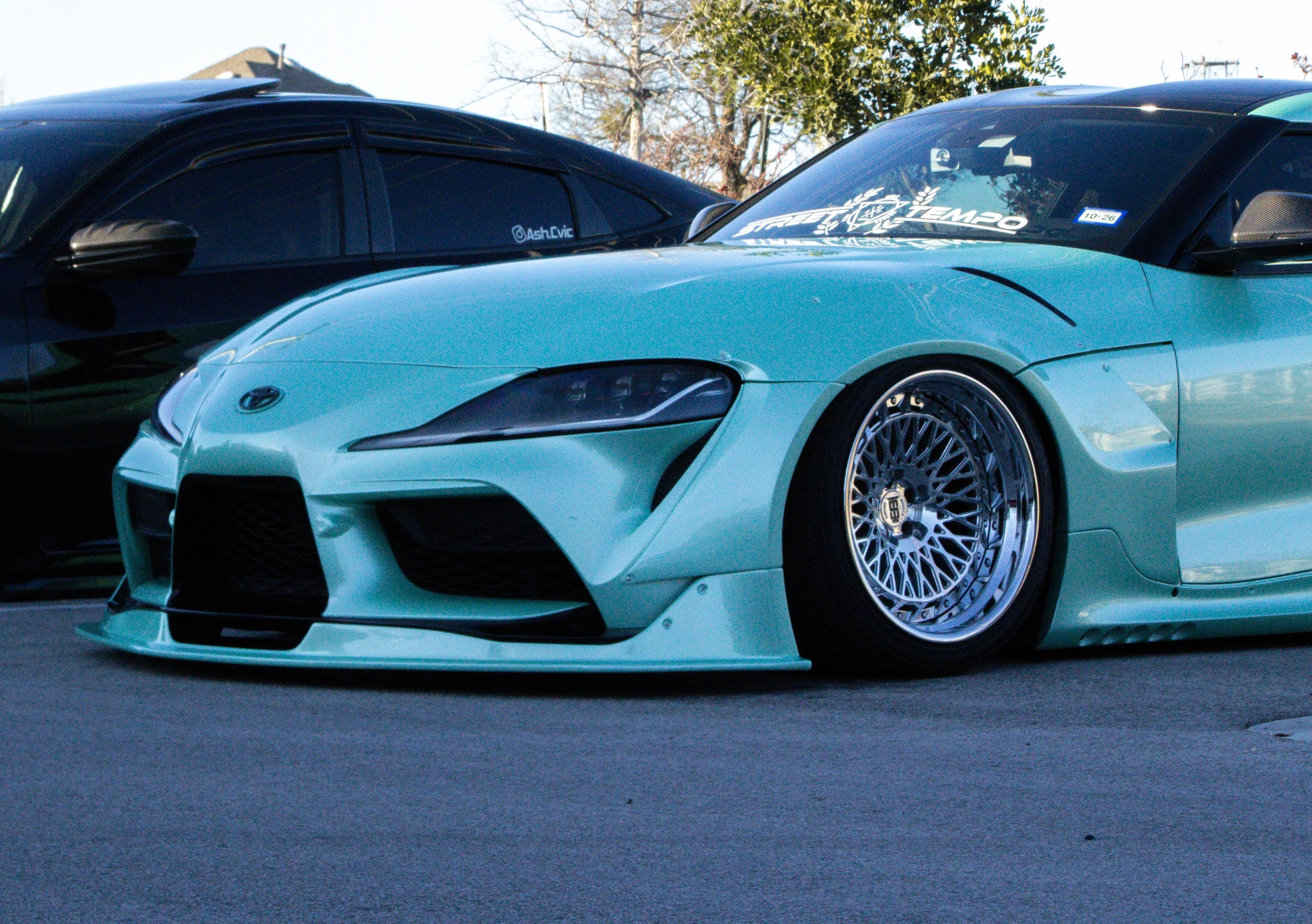 Lowered turquoise sports coupe in profile
